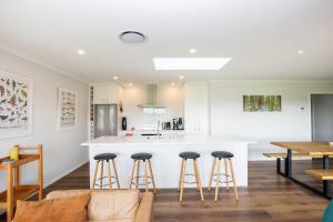 a kitchen with a counter and bar stools at Mahaki Escape in Pahautea