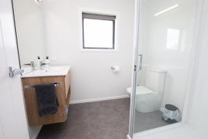 a bathroom with a toilet and a sink and a shower at Mahaki Escape in Pahautea +12 photos