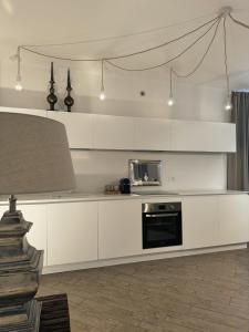 a kitchen with white cabinets and a microwave at Scirocco - Villa Marina in Marina di Andora +25 photos