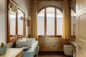 ein Badezimmer mit Waschbecken und Fenster in der Unterkunft Dimora Le Conce - Loft di Charme in Fabriano