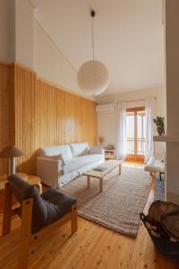 a living room with a couch and a table at VYTINA LOFTS - Cozy 2-Level Loft Apartments with Fireplace & Mountain Views in Vitina