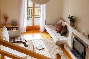 a living room with a couch and a fireplace at VYTINA LOFTS - Cozy 2-Level Loft Apartments with Fireplace & Mountain Views in Vitina
