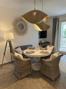 a dining room with a table and wicker chairs at Scirocco - Villa Marina in Marina di Andora