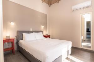 a bedroom with a large white bed and a window at Mary's Panorama Houses in Gialova +46 photos