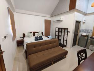 a bedroom with a bed and a couch in a room at Lanta Daisy Residence in Ko Lanta