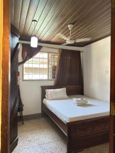 a bedroom with a bed with a wooden ceiling at Kituri Hostel in Dar es Salaam