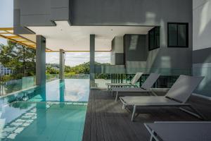 a swimming pool with lounge chairs and a house at Propify Central Serviced Residence in Ban Ket Ho