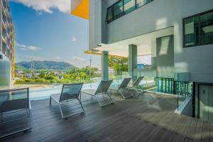a group of chairs on a balcony of a building at Propify Central Serviced Residence in Ban Ket Ho