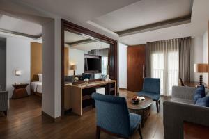 a living room with a room with a bed and a couch at Hotel Santika Mataram in Mataram