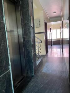 a hallway of a building with a door and a staircase at Manjusri Paradise in Bangalore