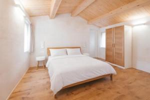 a bedroom with a white bed and a wooden ceiling at Locanda dell'Ortolano in Ferrara