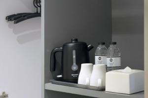 a coffee maker on a shelf in a kitchen at My Hotel Pratunam in Bangkok
