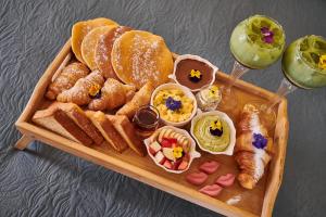 a tray of bread and pastries and a glass of wine at Fairytale Athens - Luxury Suites in Athens