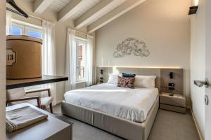 a bedroom with a white bed and a desk and window at Seety Spartaco in Milan