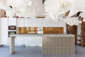 una cocina con armarios blancos y obras de arte blancas en Artkazal en Mórahalom