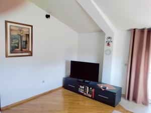 a living room with a flat screen tv on a dresser at Apartman Katić - Rental Home in Stolac