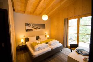 a bedroom with a bed in a room with a window at Hüttenhotel Husky Lodge in Muotathal