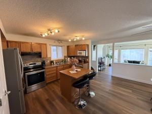 a kitchen with wooden cabinets and a island in a room at Spacious & Private Retreat near West Edmonton Mall in Edmonton