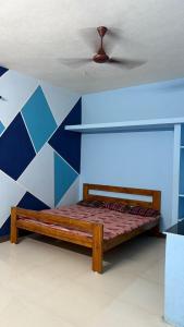 a bed in a room with a blue wall at Vignesh Home staying in Tiruvannāmalai