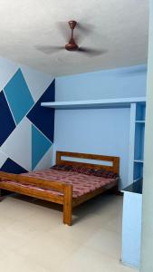 a bed in a room with a blue wall at Vignesh Home staying in Tiruvannāmalai