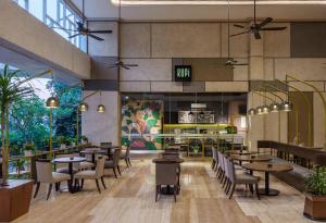 a restaurant with tables and chairs in a room at Hotel Santika Mataram in Mataram