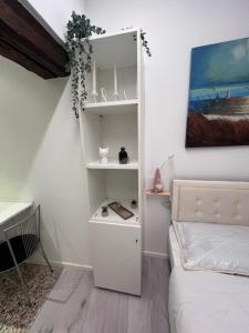 a room with a white book shelf and a bed at Comfort Room in Treviso