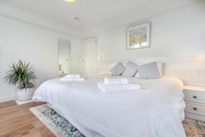 a white bedroom with a large white bed with white pillows at 4 Bed in Pentewan oc-edghil in Pentewan