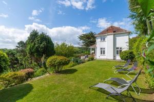 a group of chairs sitting on a lawn in front of a house at 4 Bed in Pentewan oc-edghil in Pentewan