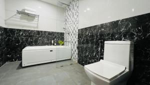 a black and white bathroom with a toilet and a sink at Amani by BluO - Boutique Hotel Goa in Anjuna +34 photos