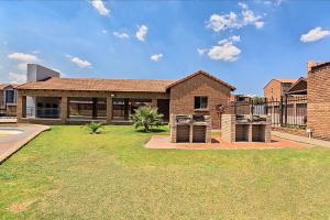 a brick house with a yard in front of it at Calmwood Stay in Midrand