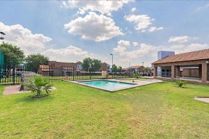 a swimming pool in the yard of a house at Calmwood Stay in Midrand