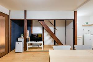 a living room with a tv and a table and chairs at YAGARA TERRACE HOUSE OSAKA Room B in Osaka
