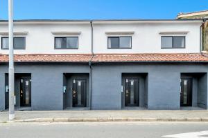 a white building with black doors and a red roof at YAGARA TERRACE HOUSE OSAKA Room B in Osaka