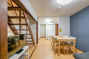 a dining room with a wooden table and a ladder at YAGARA TERRACE HOUSE OSAKA Room B in Osaka