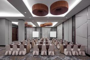 a conference room with tables and chairs and screens at Hotel Santika Mataram in Mataram +18 photos