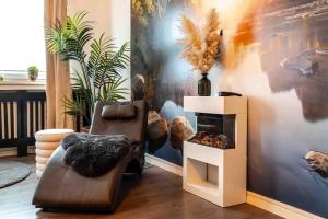 a living room with a chair and a fireplace at Wellness Suite mit Whirlpool und Sauna in Ahlen