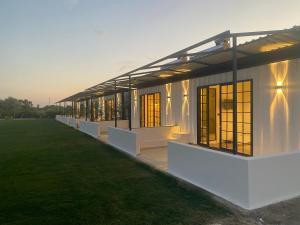 a white building with windows and a grass field at Casamora in Edremit