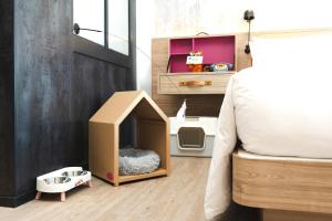 a room with a dog house next to a bed at Moxy Bangkok Ratchaprasong in Bangkok