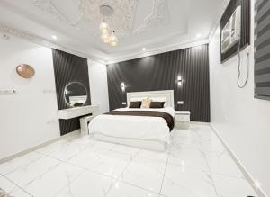 a bedroom with a white bed and a black wall at مرافئ in Medina +6 photos