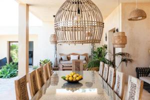 a dining room with a table with a bowl of fruit on it at Villa Sirio in Cala de Bou