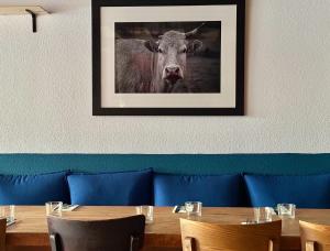 a table with a picture of a cow on the wall at Hôtel-Restaurant de La Paix in Saint-Palais