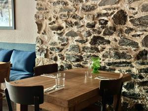 a wooden table with chairs and a stone wall at Hôtel-Restaurant de La Paix in Saint-Palais +37 photos