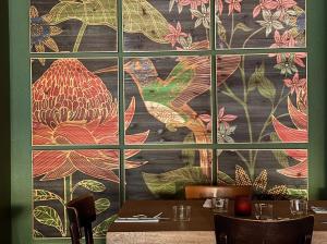 a large window in a restaurant with a large mural at Hôtel-Restaurant de La Paix in Saint-Palais