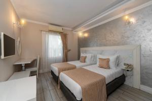 a hotel room with two beds and a sink at Porto Azul Hotel Bodrum in Bodrum City