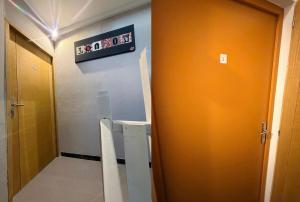 a bathroom with an orange door and a sign on the wall at La coloc suédoise in Calais +27 photos