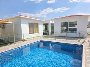 a swimming pool in front of a house at Wadi Bani Khalid - Al Joud Green Hostel in Zilaft