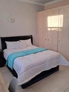 a bedroom with a bed with a blue and white blanket at Mapungubwe hotel unit 525 in Johannesburg +5 photos
