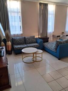 a living room with a blue couch and a table at Mapungubwe hotel unit 525 in Johannesburg