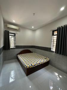 a bedroom with a bed in the corner of a room at Tổ Nhím Homestay in Ấp Cái Chuối