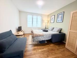 a living room with a bed and a couch at La perle suedoise - Studio avec terrasse et cour privée in Calais